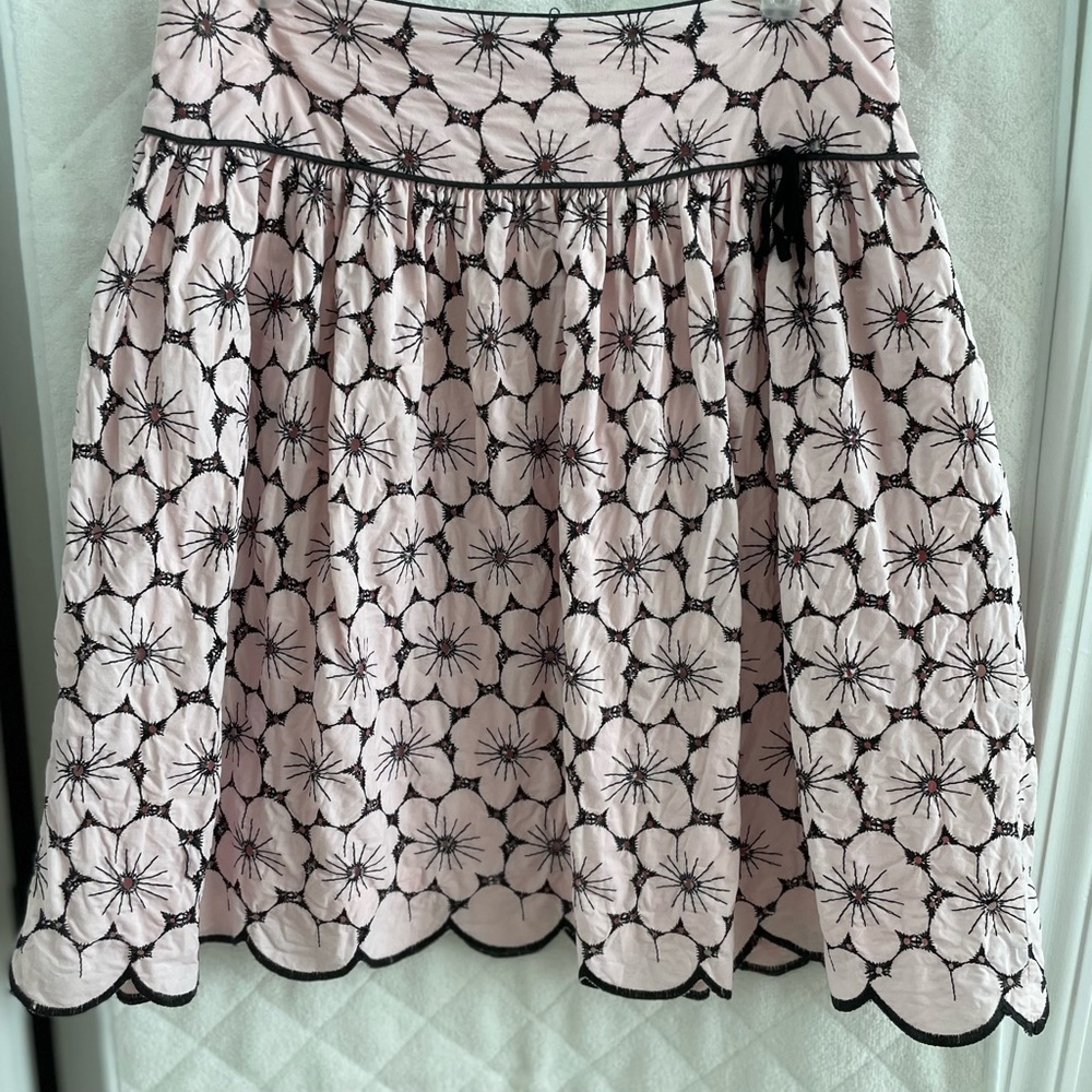 Pink and black eyelet skirt with scalloped hem.